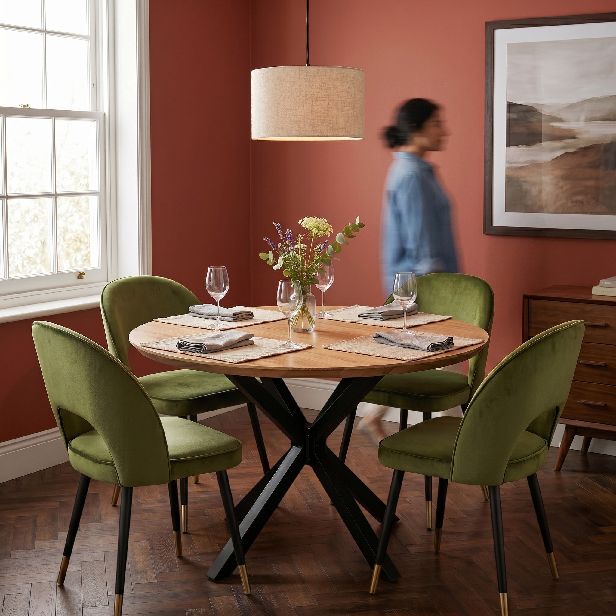 Dining room with wooden table and green chairs against a red wall.