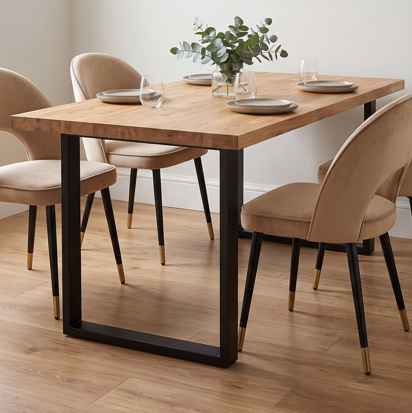 A rectangular solid oak dining table with a thick natural oak top and black metal frame legs, surrounded by four upholstered dining chairs.
