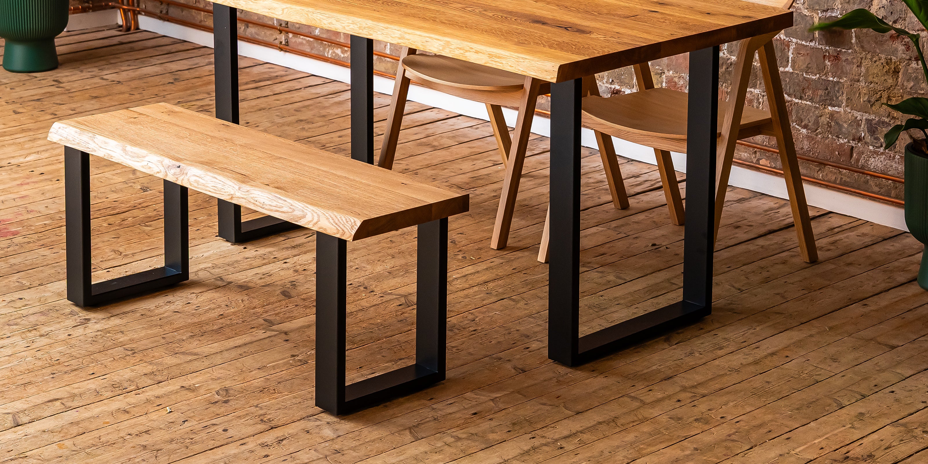 Solid oak live edge bench with metal legs and matching dining table.