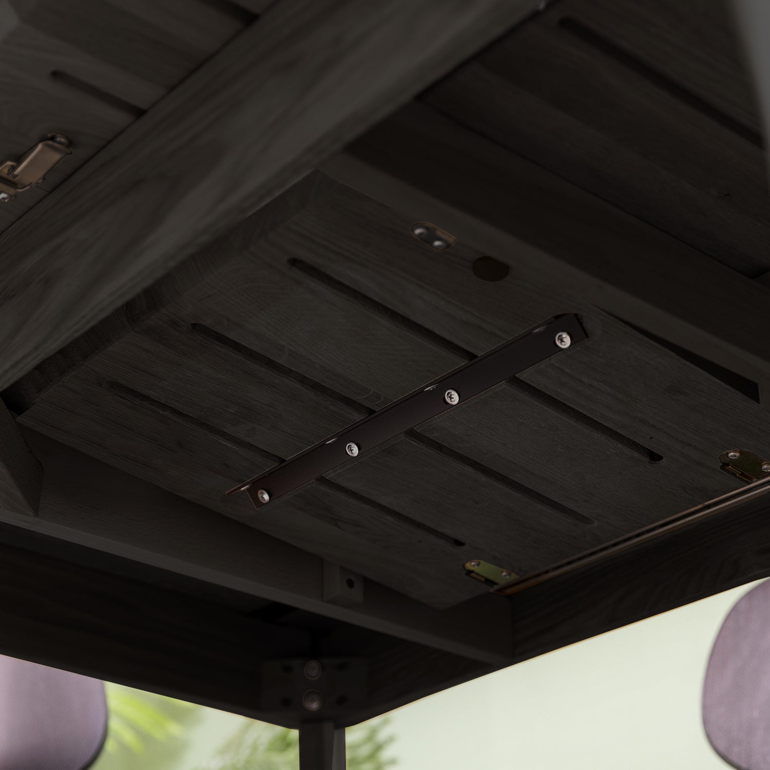 Close-up of the underside of the black oak extendable dining table, displaying the folding mechanism.