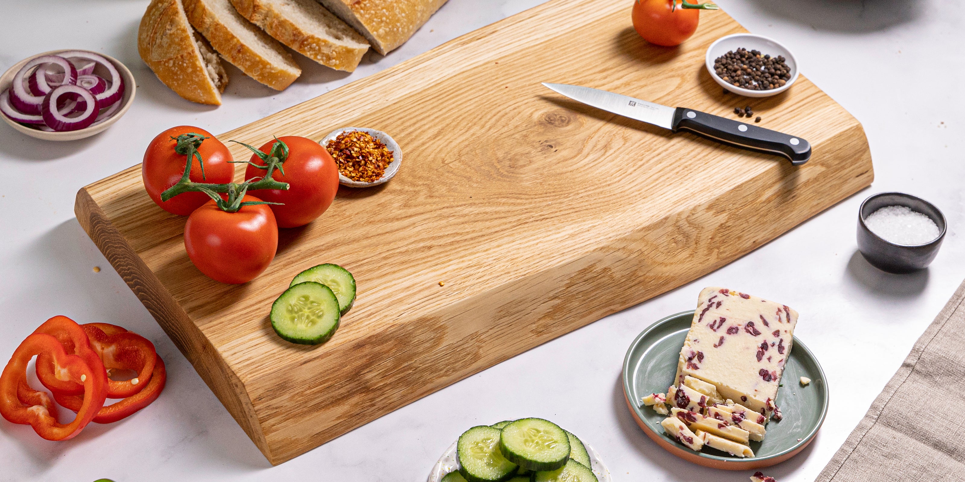 Live edge oak chopping board showing natural grain, styled with fresh ingredients.