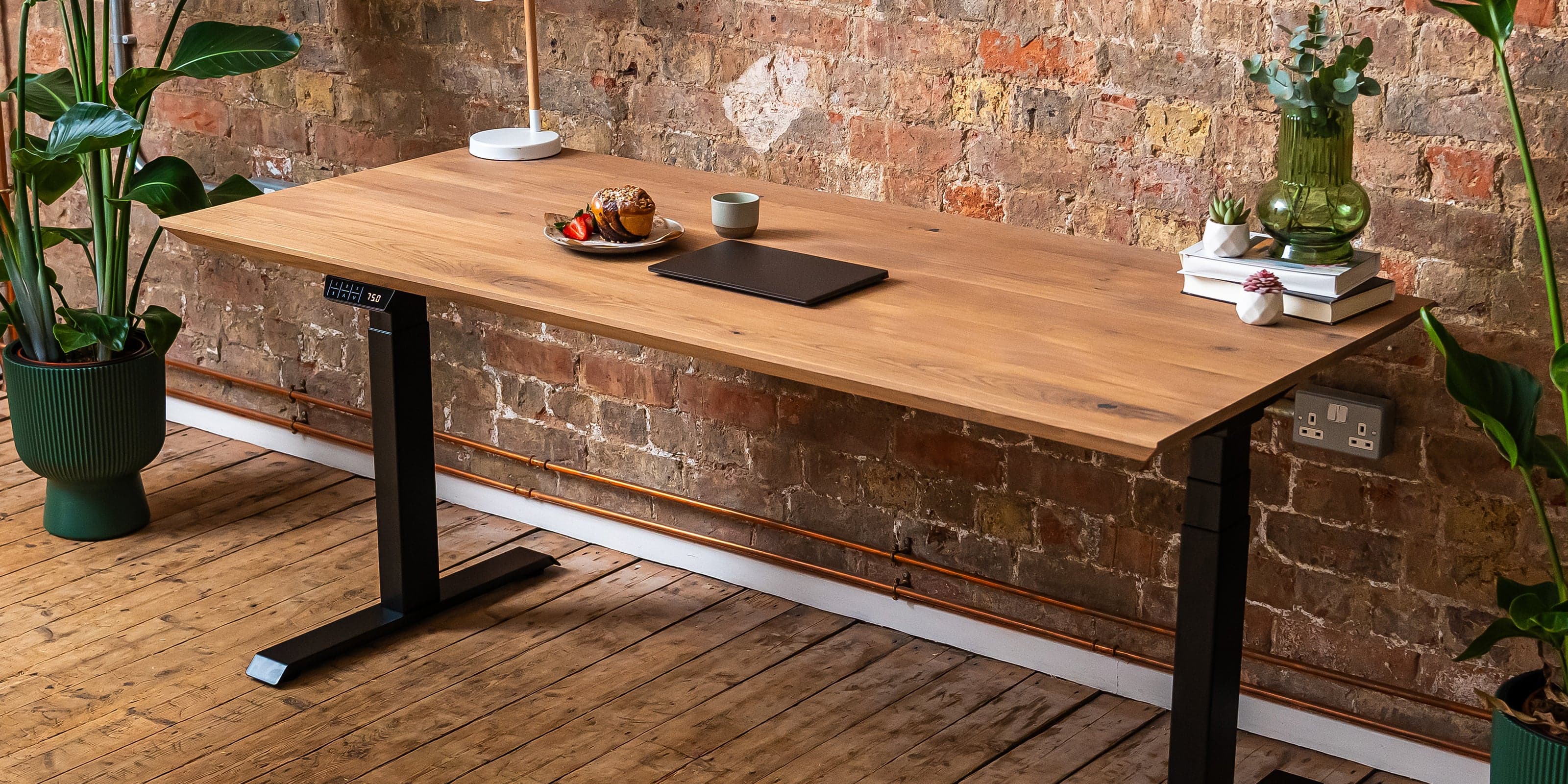 Solid wood oak desk with premium standing desk frame, in office setting.