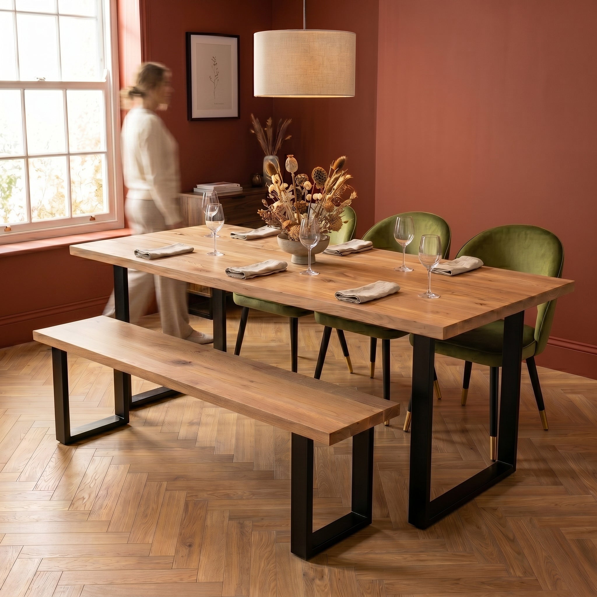 Dining room with premium wooden table, chairs, and bench against a red wall.