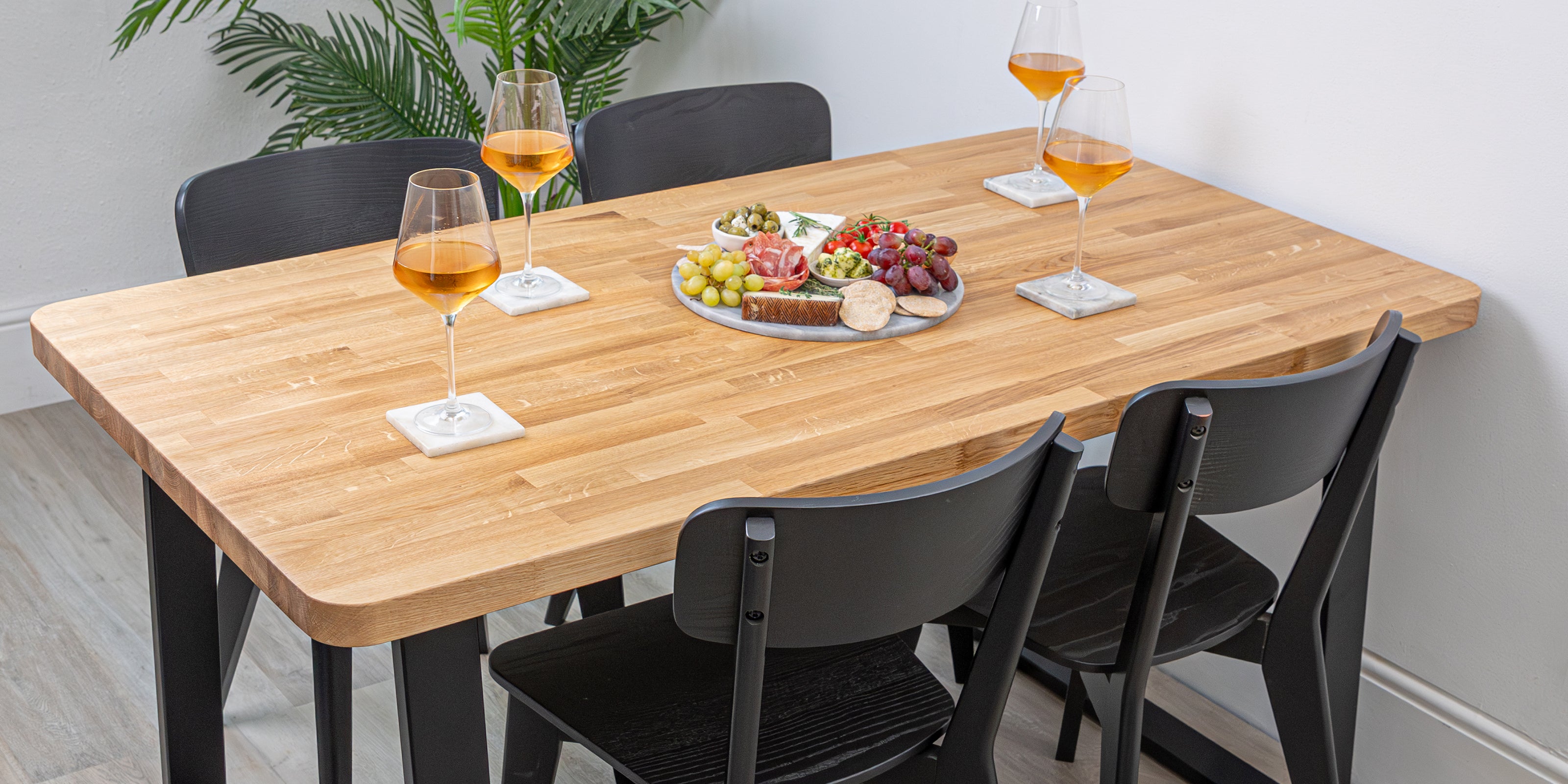 Prime oak solid wood table with glasses of wine and a plate of food in a room.