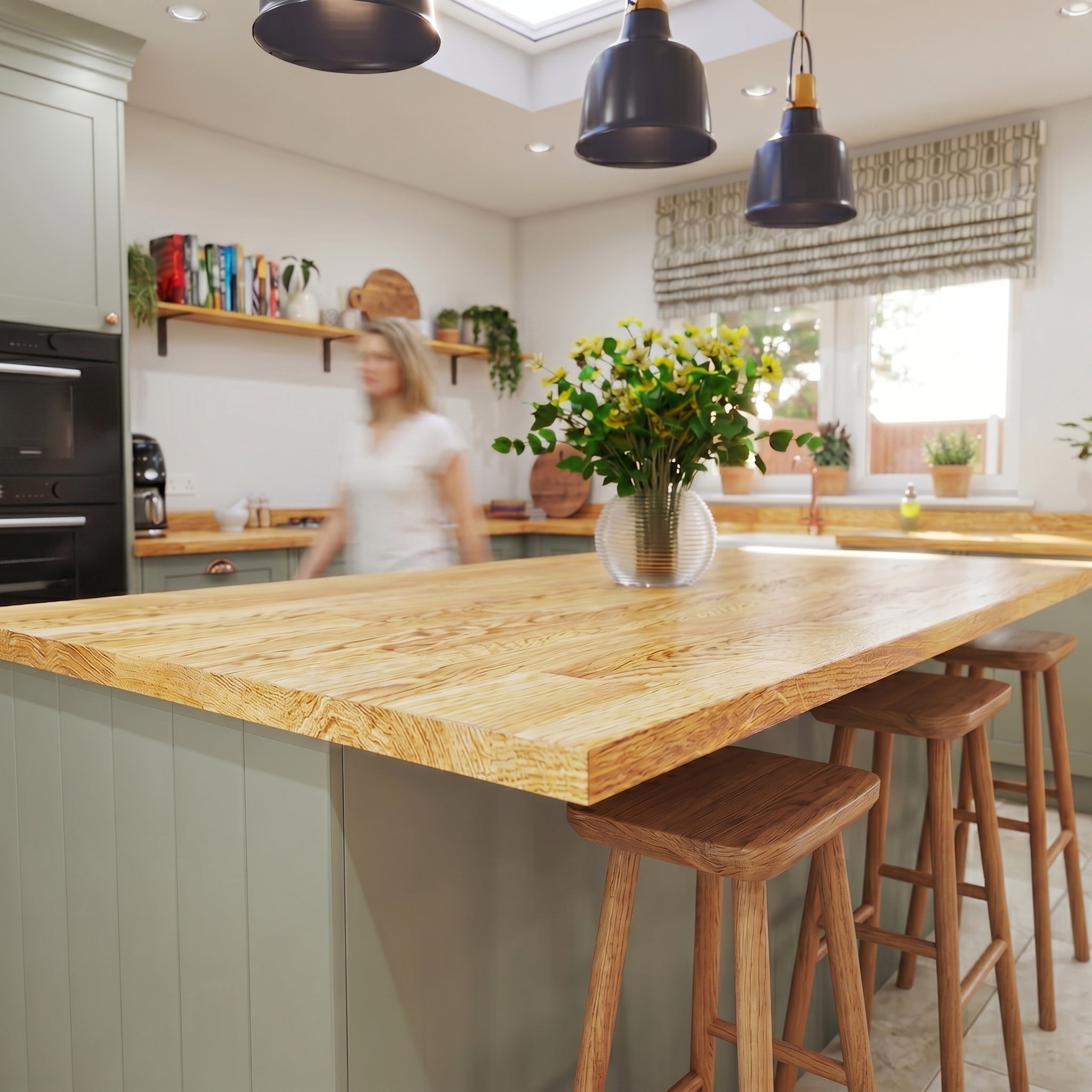 Oak kitchen with wooden island and stools, blurred person in the background