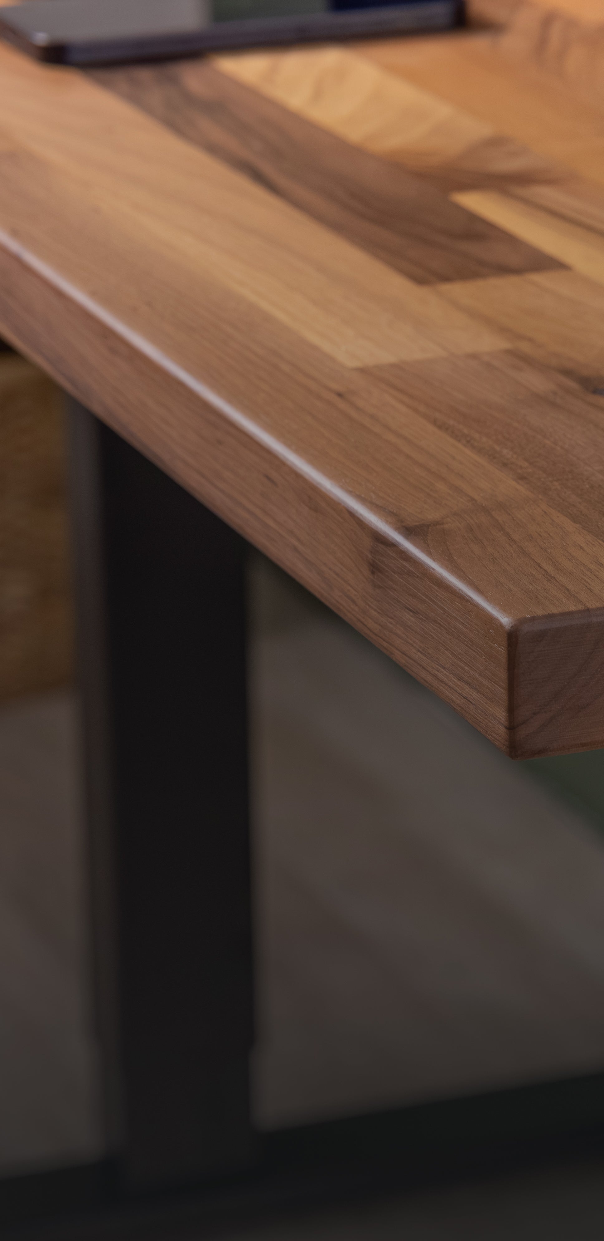 Close-up of a solid wood desktop edge, showing the natural grain and smooth edge detail.
